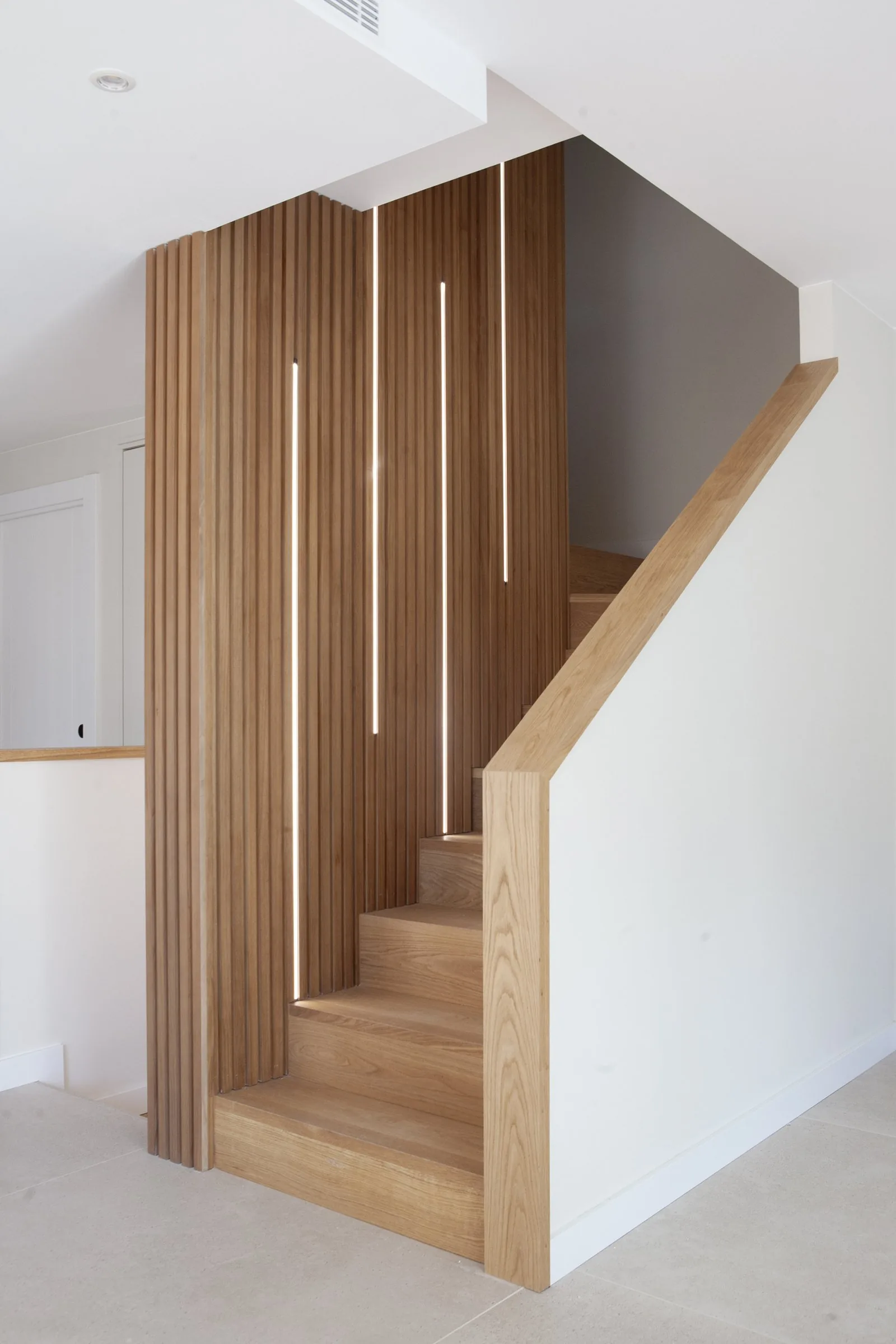 La escalera de listones de roble macizo de la obra AM15