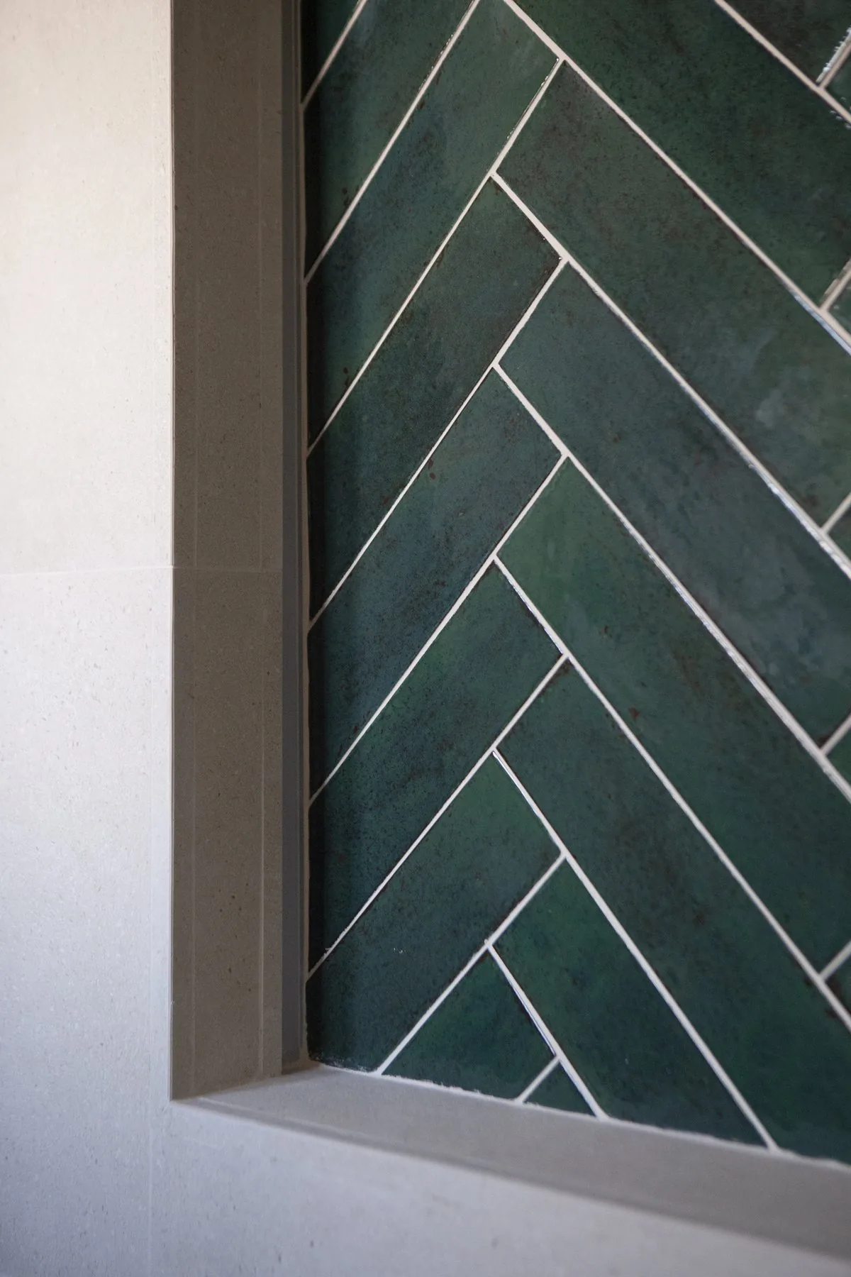 Detalle del alicatado en espiga verde oscuro de Dune, en el baño principal