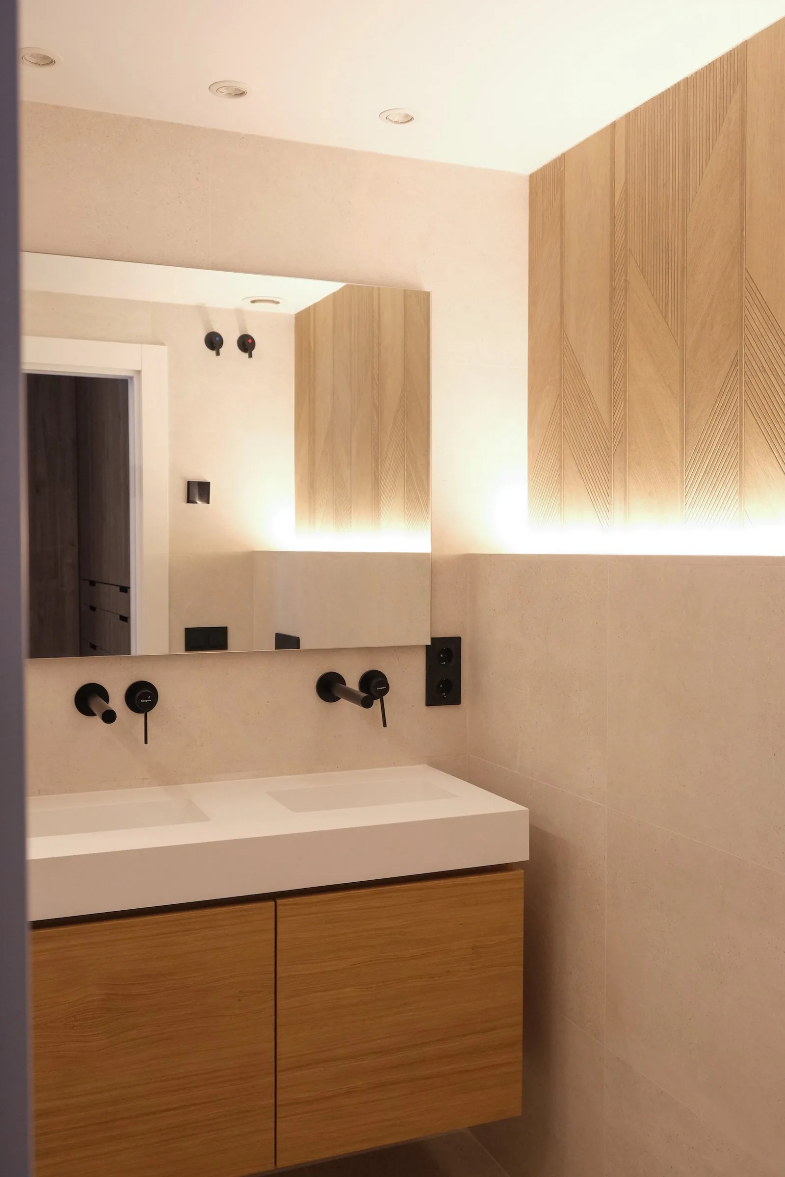 El lavabo del tercer baño, con mueble suspendido y espejo retroiluminado