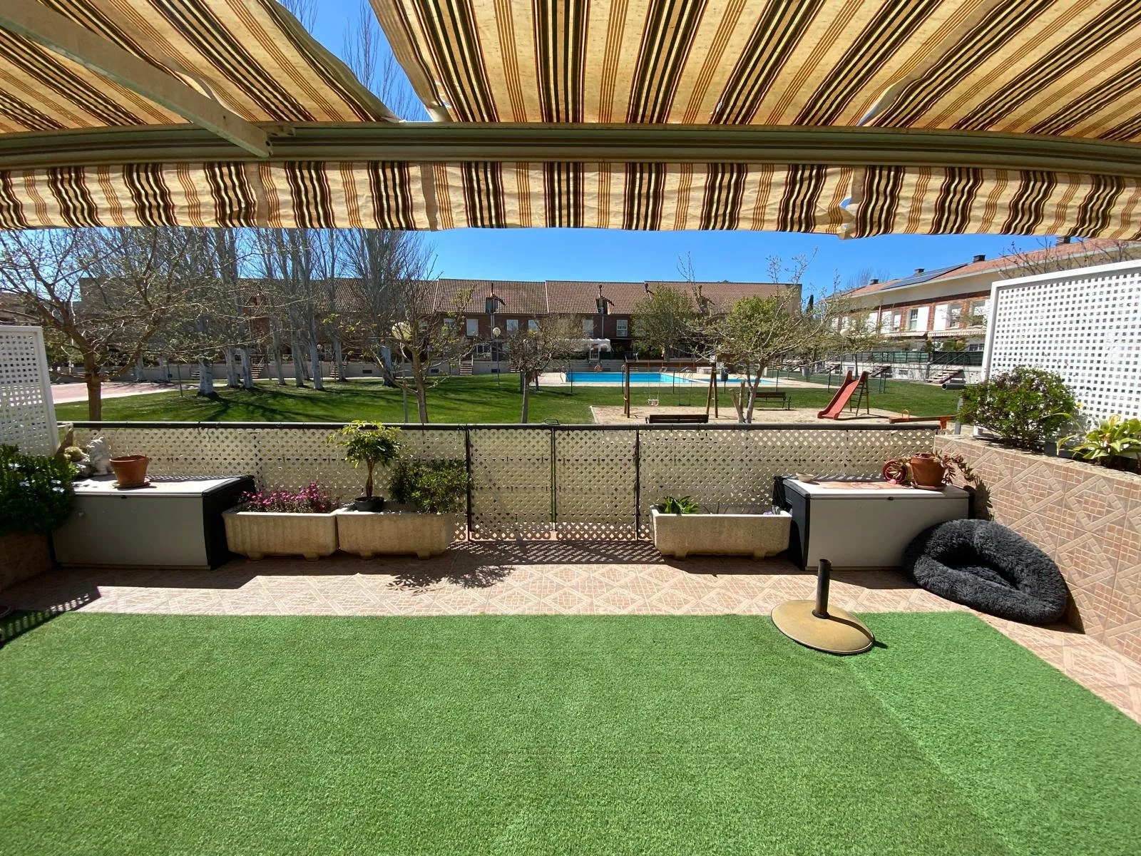 La antigua terraza exterior de 50 m², con césped artificial y toldo
