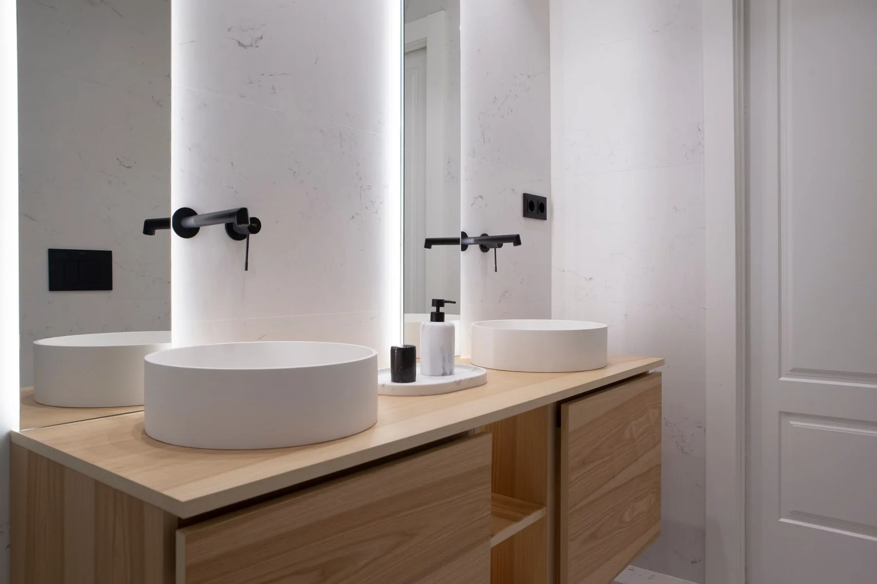 Baño suite PP5 con mueble de madera clara, doble lavabo y espejo retroiluminado en Zaragoza