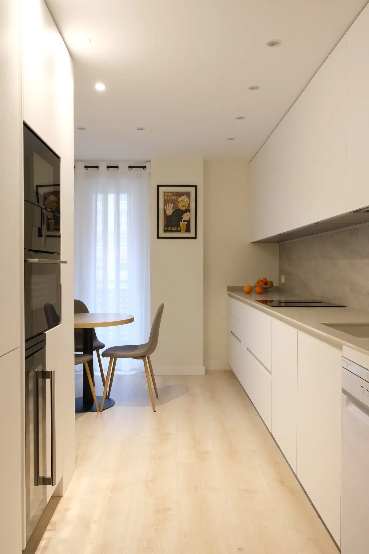 La cocina nueva en esa misma pieza, con el frente claro y la mesa al fondo