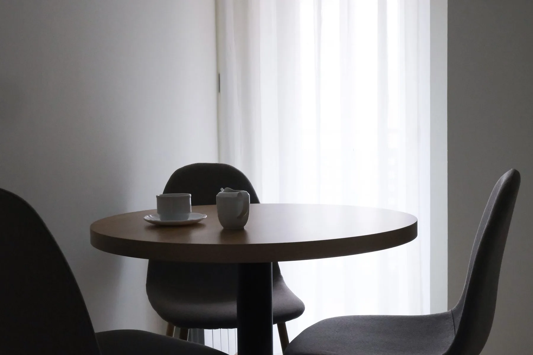 La mesa redonda con dos sillas junto a la ventana, dentro de la cocina