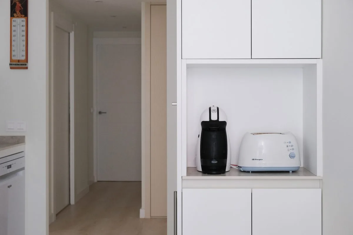 El hueco de office abierto, con la tostadora y la cafetera, junto al paso