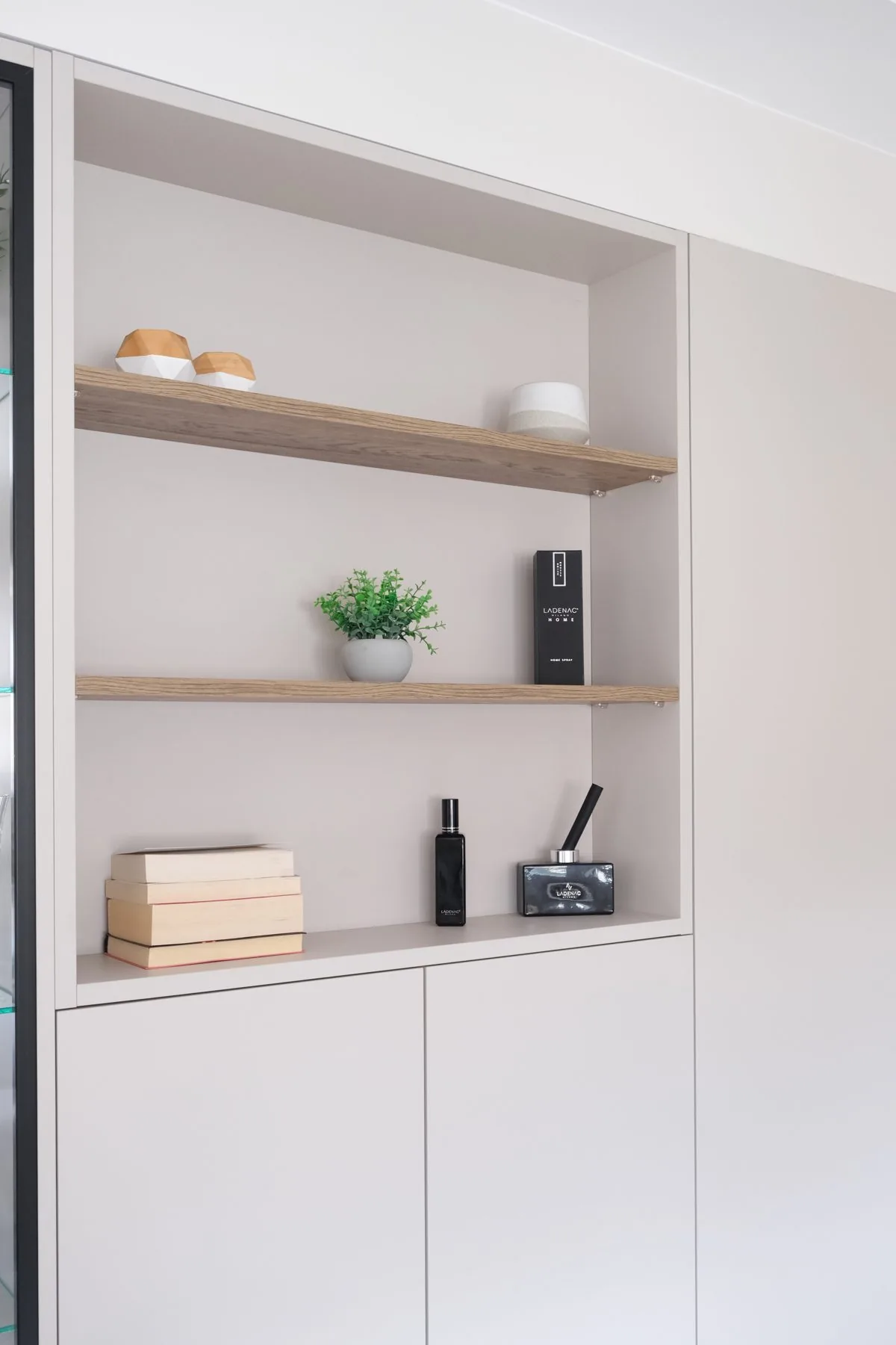 La hornacina con baldas de roble sobre el mueble bajo lacado, fabricado a medida