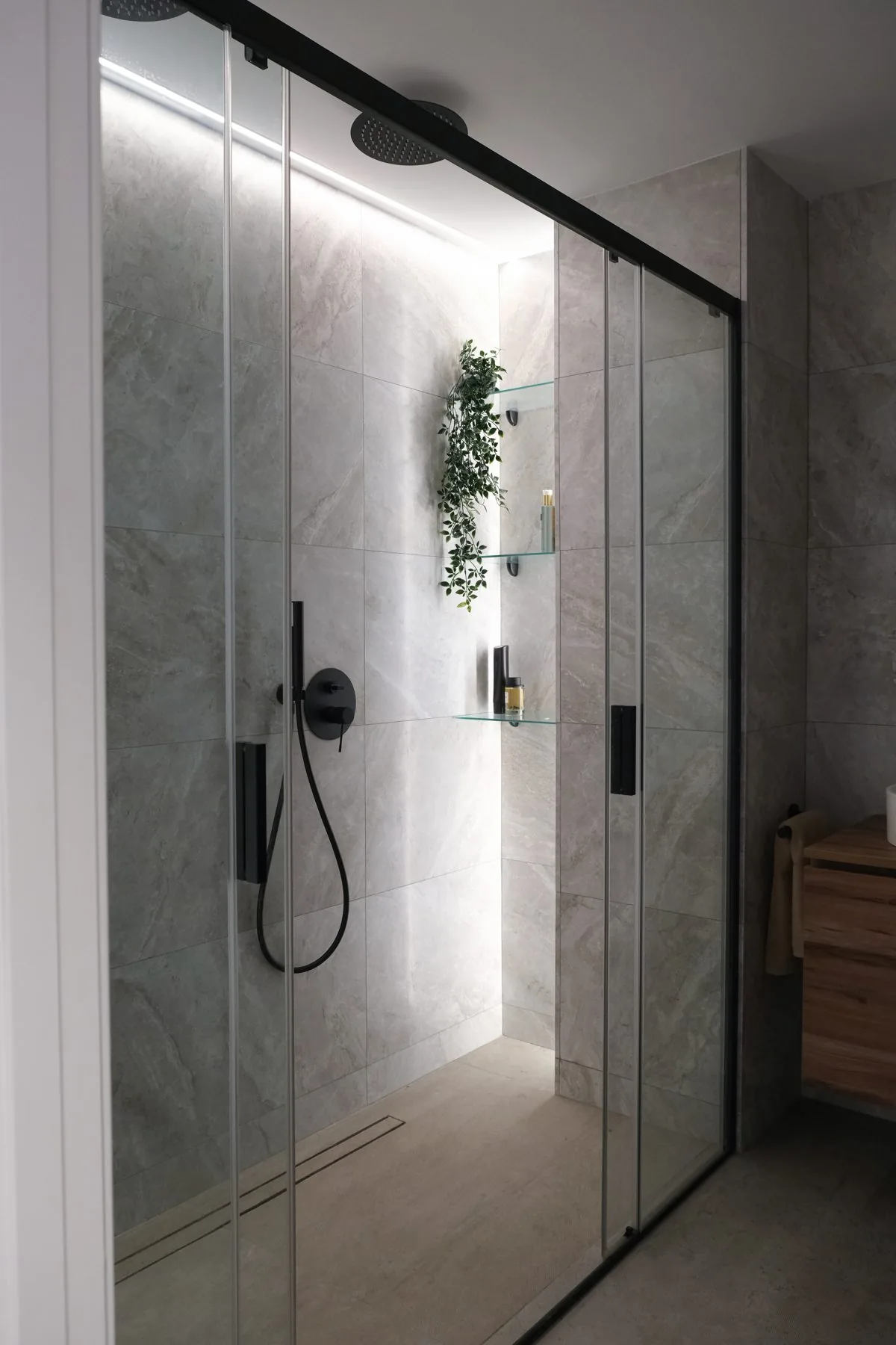 Baño suite: la ducha con mampara corredera y las hornacinas de vidrio
