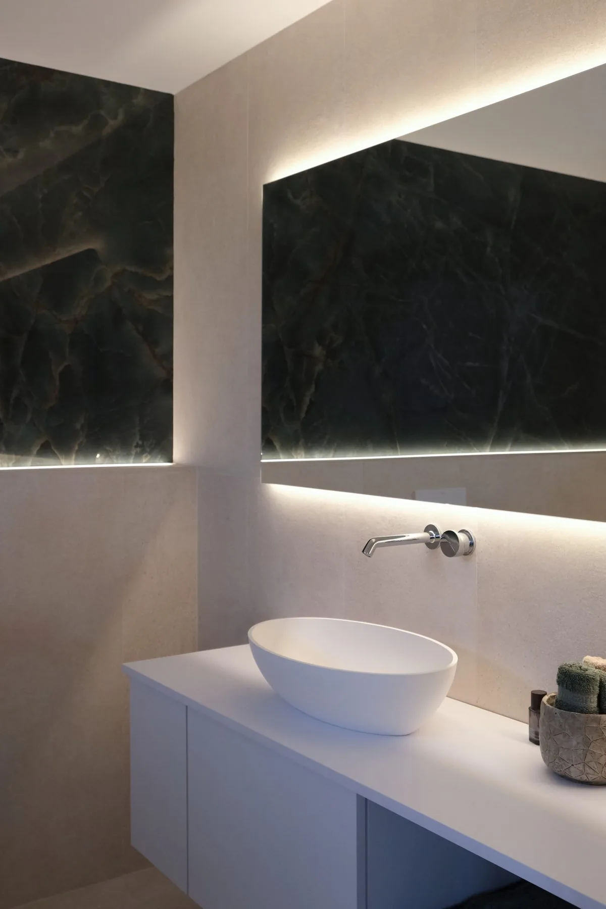 Baño principal: el lavabo ovalado y el frente de mármol verde de Porcelanosa