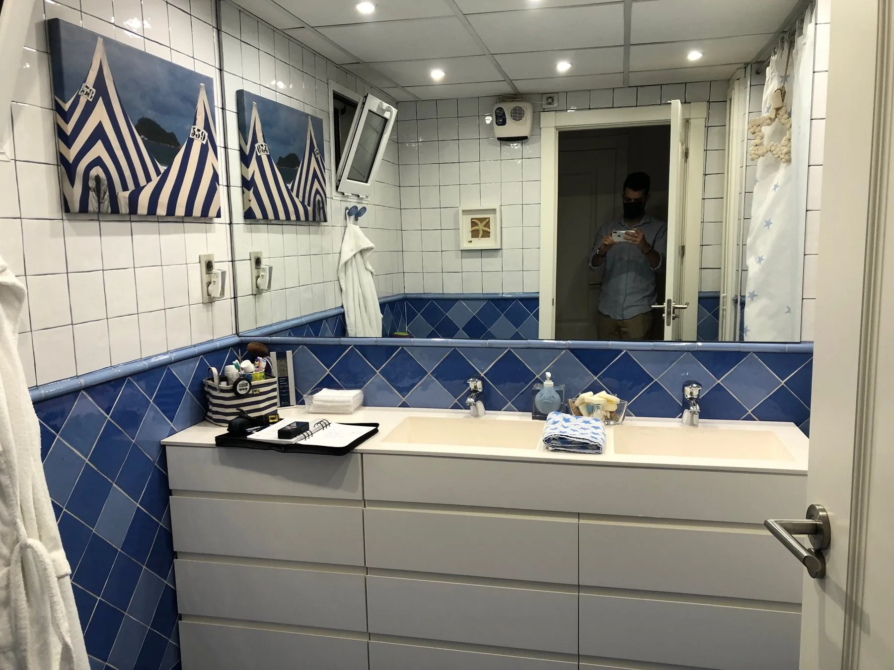 El mismo paño antes de la obra, con el mueble y el espejo sobre el azulejo azul en rombos