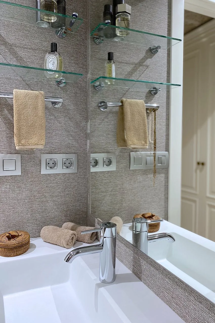 La encimera blanca del baño suite con el lavabo integrado y el espejo retroiluminado