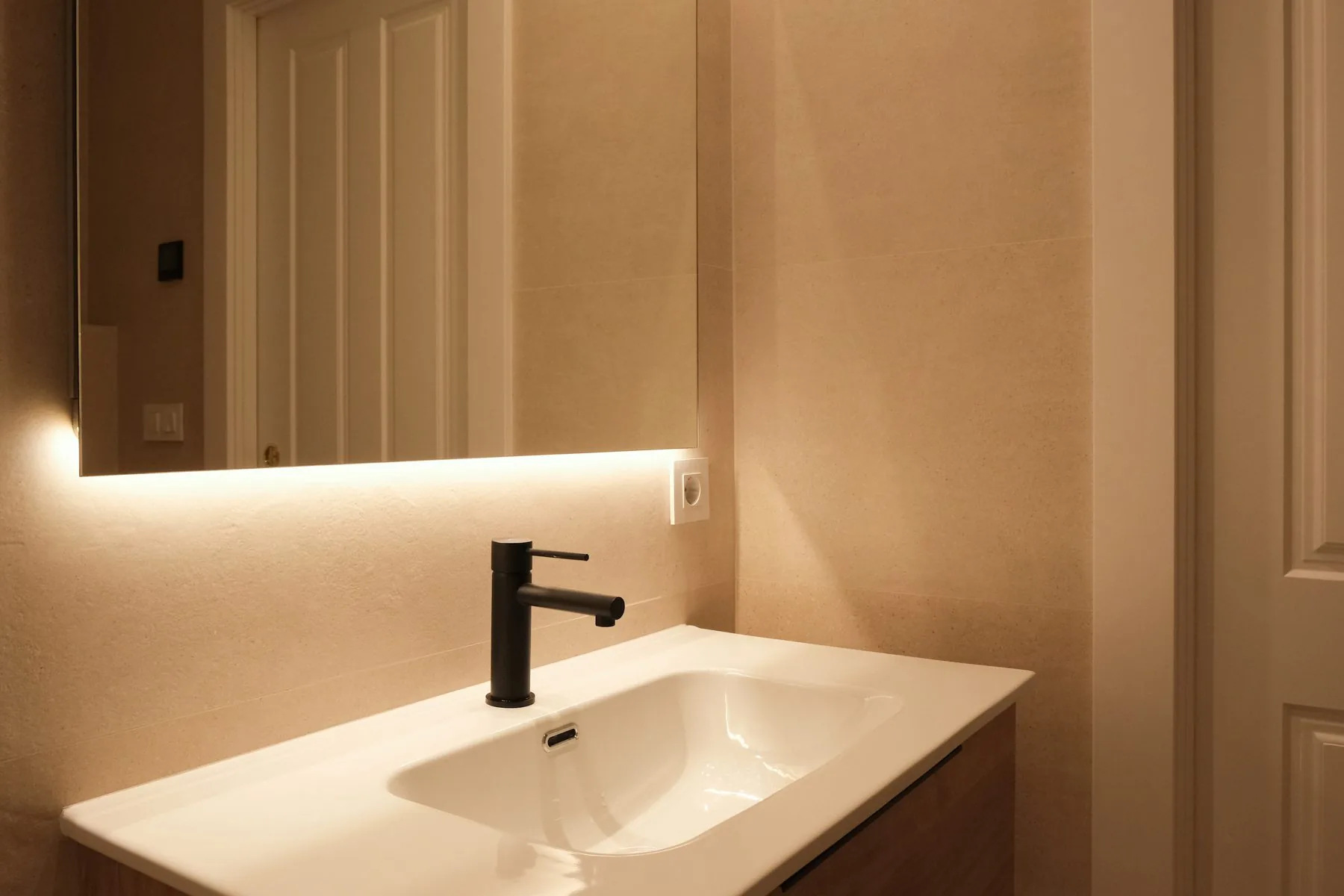 Baño general: el lavabo rectangular sobre el mueble de madera