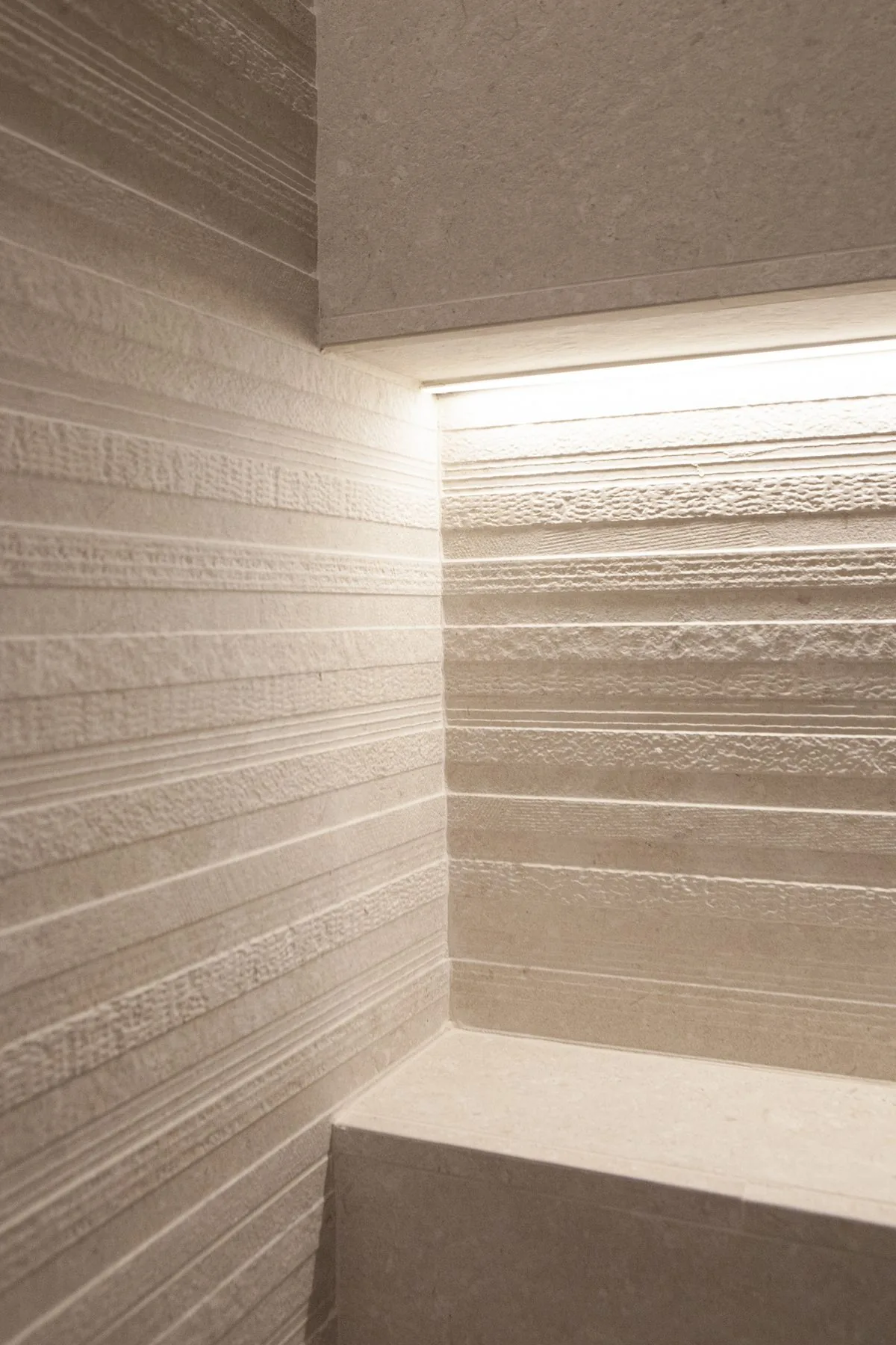 La ducha hoy, con la pared de textura rayada y la hornacina iluminada