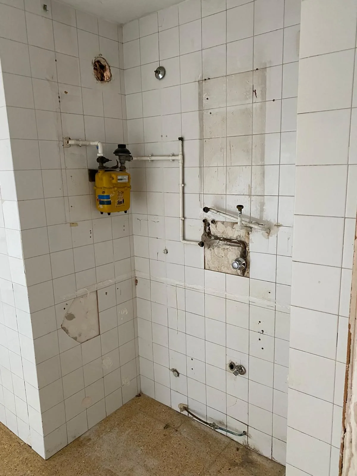 El paramento de la ducha durante la obra, con las tomas de agua vistas antes de revestir