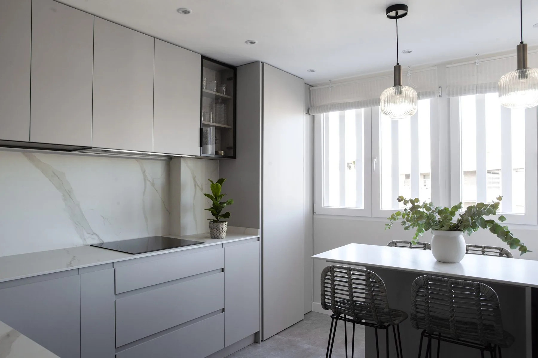 La cocina terminada, con el frente taupe, la campana integrada y la península — obra PN6