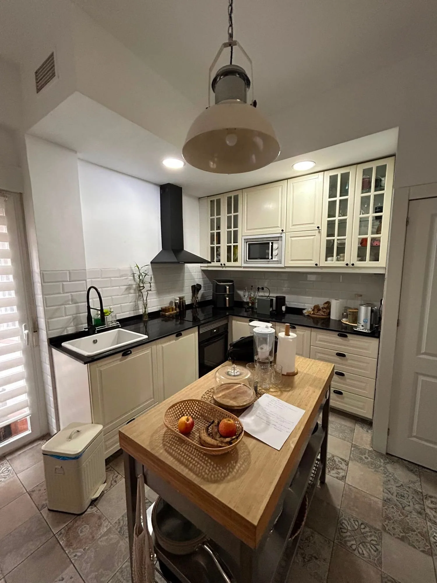 La misma cocina antes de la obra: cerrada, con la freidora de aire y todo a la vista sobre la encimera