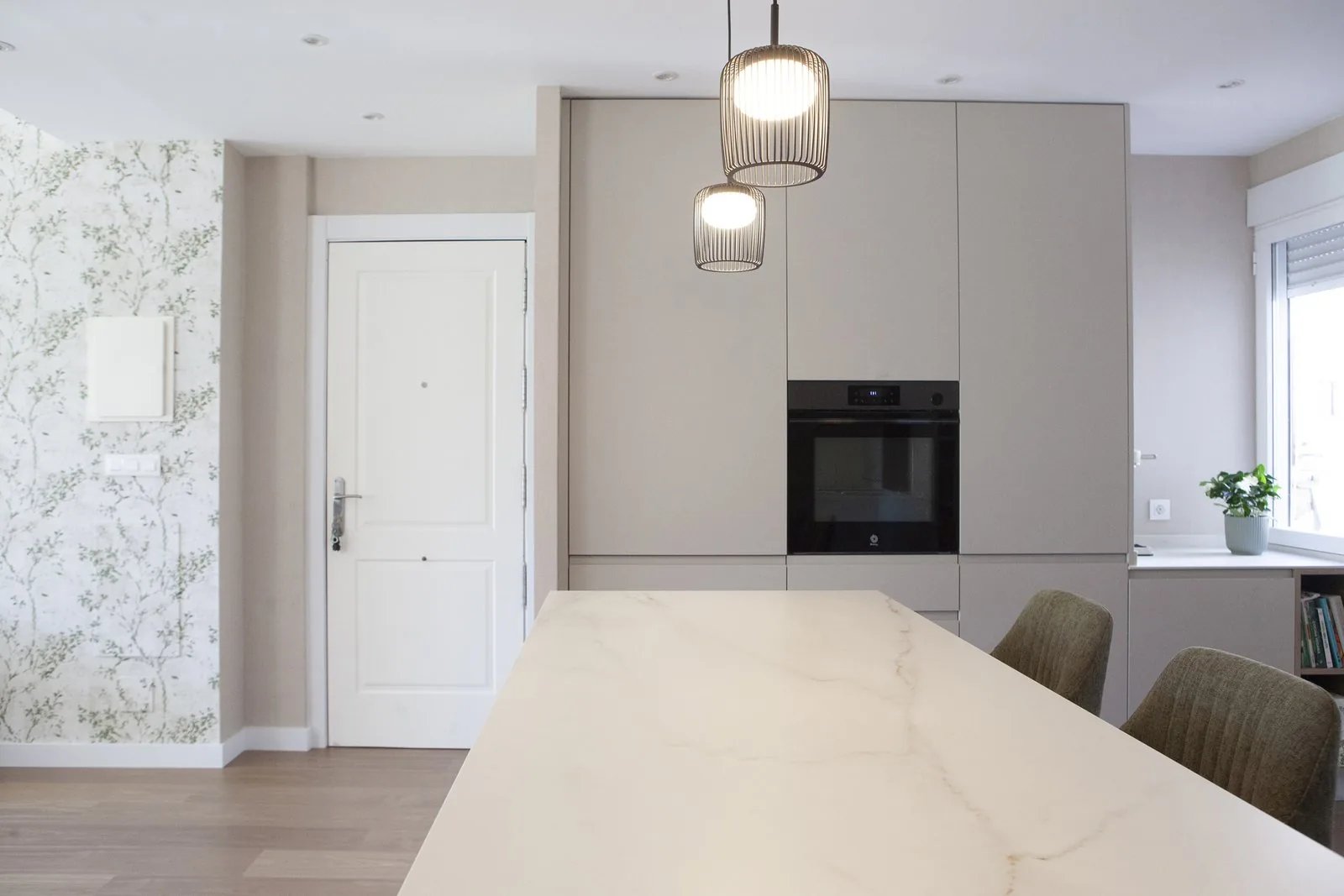 El frente de la cocina con la hornacina de madera y la línea de luz bajo los muebles altos