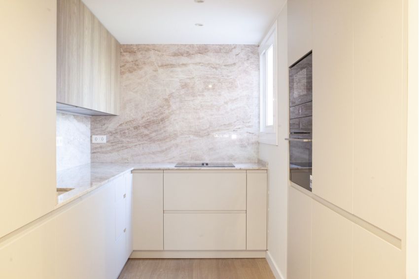 Mueble de baño suspendido en madera natural con cajón y hueco abierto, lavabo sobre encimera cilíndrico blanco y espejo rectangular con retroiluminacion LED perimetral